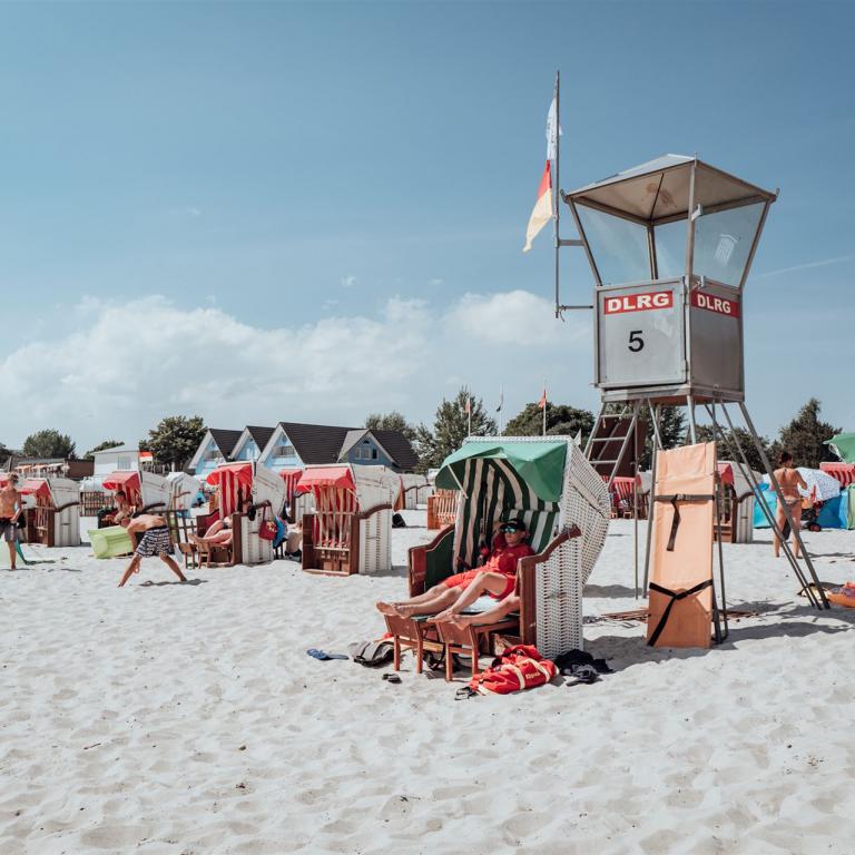DLRG Wachturm, Wachpersonal sitzt im Strandkorb davor.