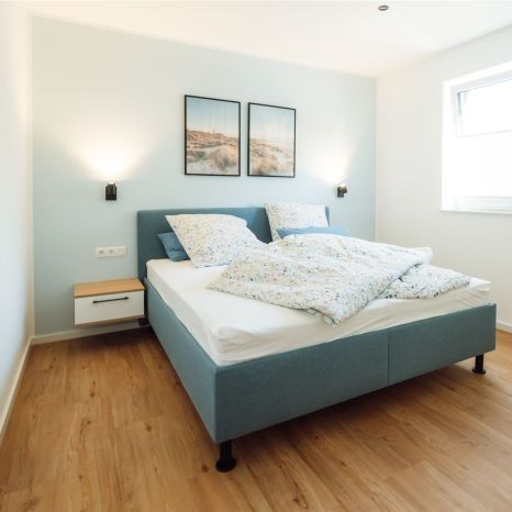 Quartier 18, Wohnung 1, Boxspringbett und Spiegel im Schlafzimmer